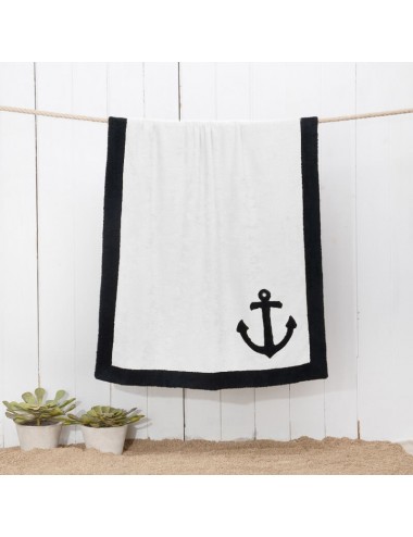 Sand-colored terry cloth beach towel with black terry cloth edge and a sea anchor patchwork embroidery